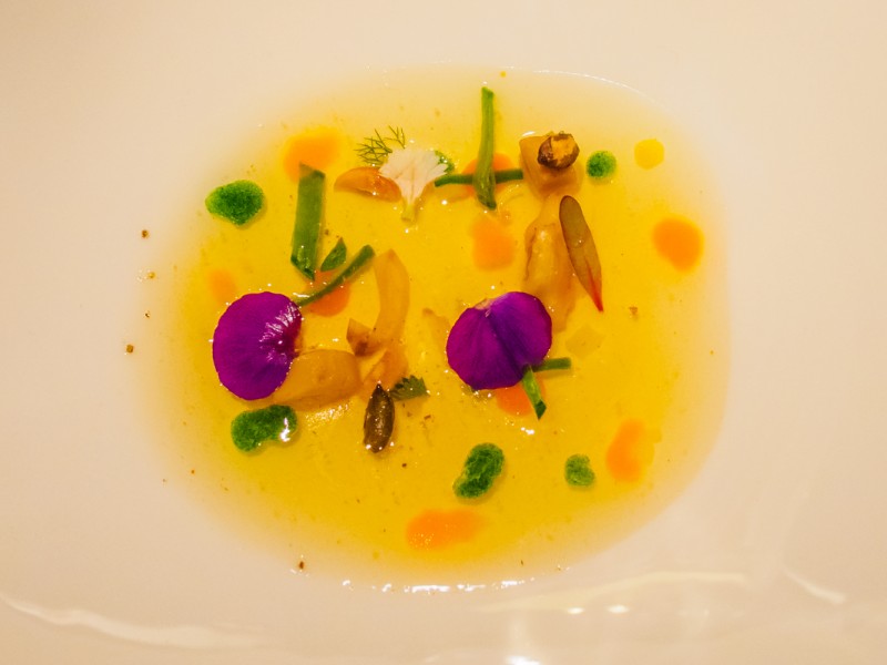 Consomé de carbassa amb te verd tofu d'avellana, xirivia, liquat de carbassa, liquat d'espinacs, suc de fruita de la passió, pipa de carbassa, nap i castanya a la brasa